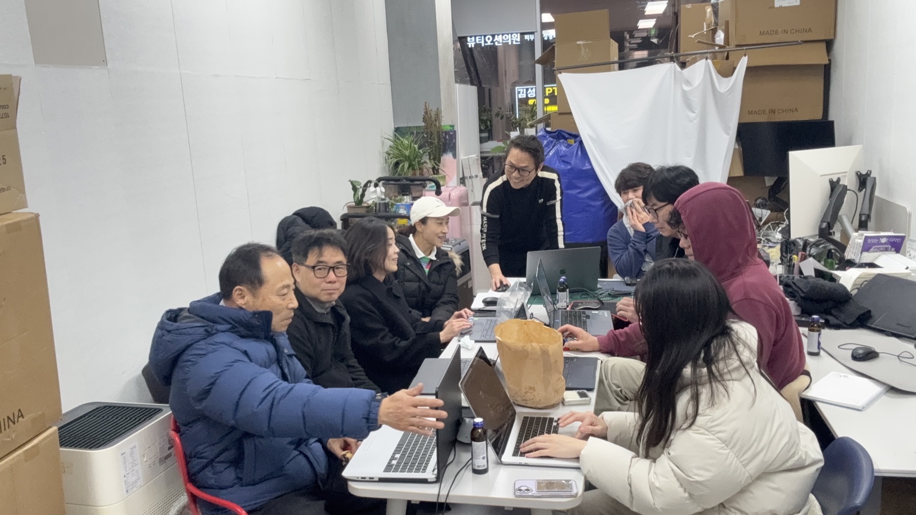 워크숍 테이블에 모여 작업하는 모습